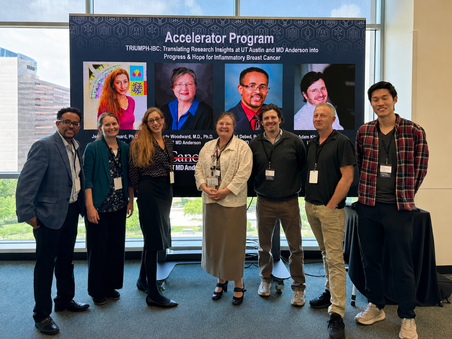 A group of seven people stand in front of a screen depicting their headshots at a presentation.