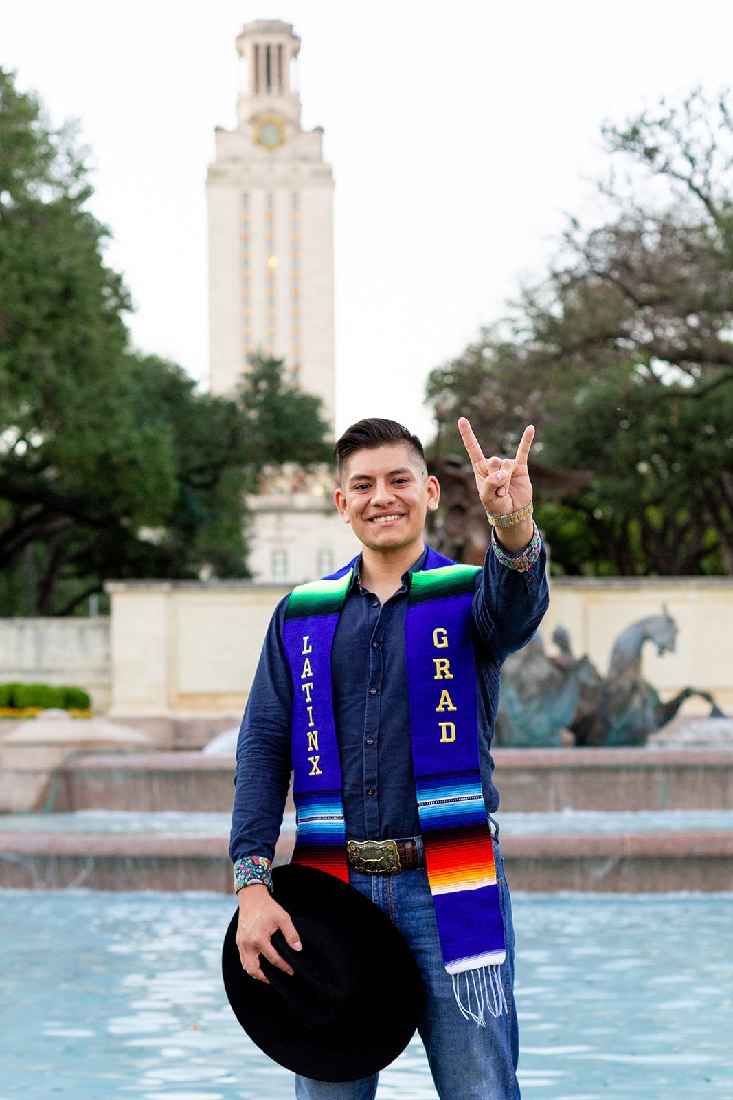 image of a student standing in a fountain in graduation regalia