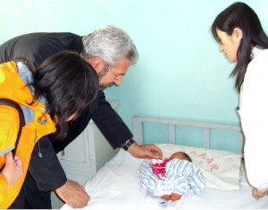 Richard Finnell with a newborn baby in Lanxing province