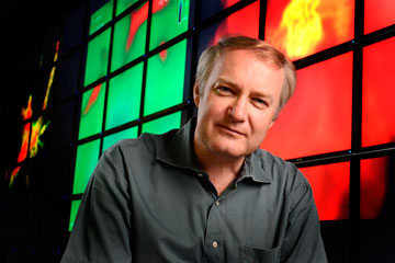 Volker Bromm sits in front of one of his universe visualizations