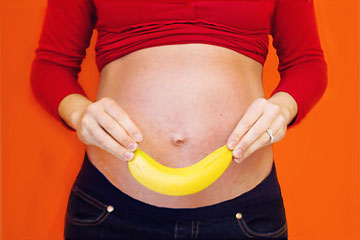 Pregnant woman holding a banana