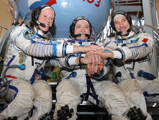 At the Gagarin Cosmonaut Training Center in Star City, Russia, Expedition 36/37 Flight Engineer Karen Nyberg of NASA (left), Soyuz Commander Fyodor Yurchikhin (center) and Flight Engineer Luca Parmitano of the European Space Agency clasp hands April 30 as they began final qualification training for their launch to the International Space Station. The three crew members will launch May 29, Kazakh time, in their Soyuz TMA-09M spacecraft from the Baikonur Cosmodrome in Kazakhstan for a 5 Â½ month mission on the international outpost. Photo credit: NASA/Stephanie Stoll