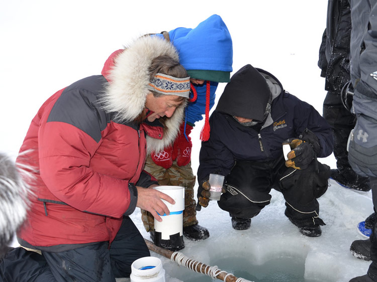 Marine science professor Ken Dunton takes water samples with high school students from Kaktovik, Alaska. Through the Student Sampling Program, students interns are paid to collect samples throughout the year. Their dataset will be the first of its kind.