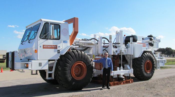 Brady Cox, civil engineer, with T-Rex, a 64,000-pound shaker truck before their trip to New Zealand to conduct earthquake research.