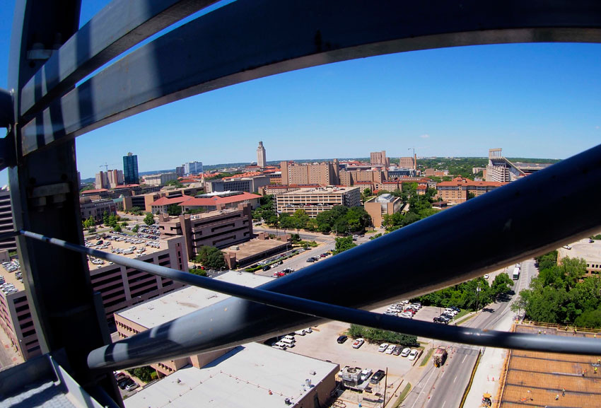 view of UT Tower through crane structure at Dell Medical School site