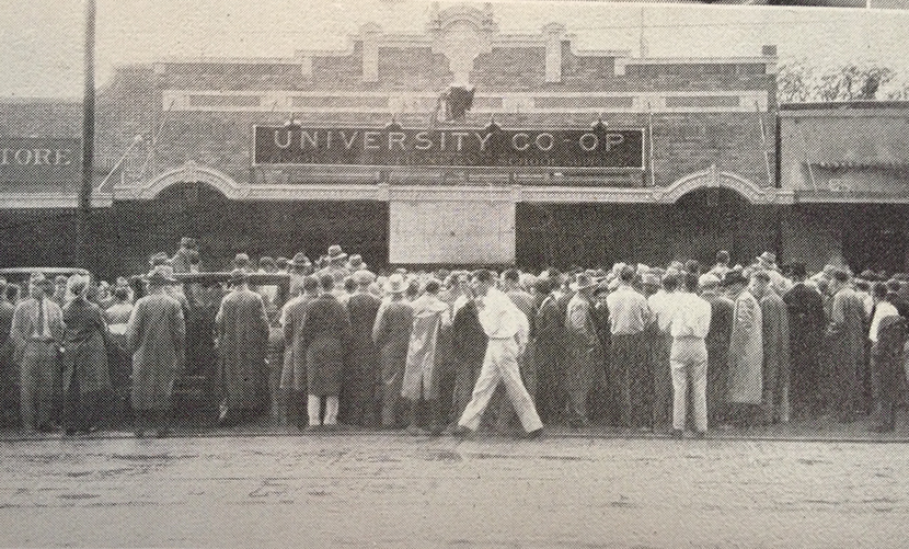 Students and fans gather on the Drag to watch updates on away games from the Co-op.