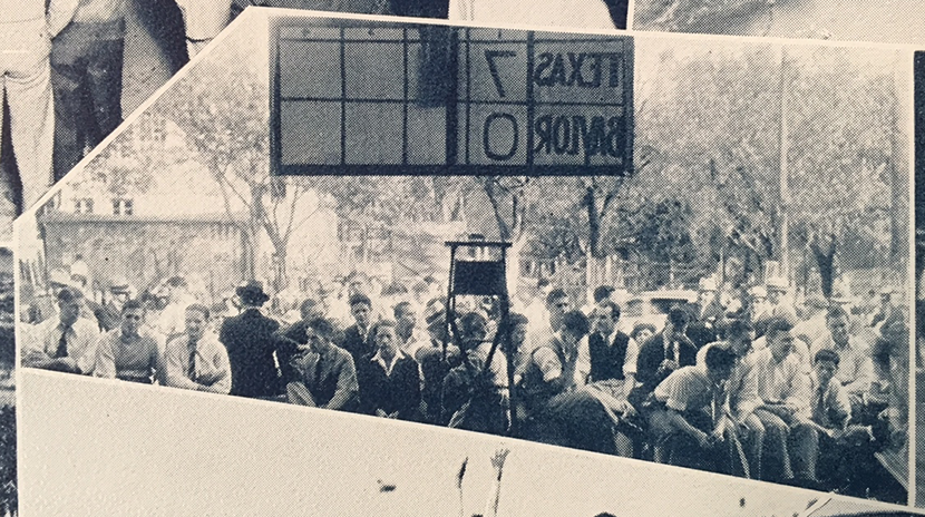 A scoreboard outside the Co-op shows the score of an away game as fans watch.