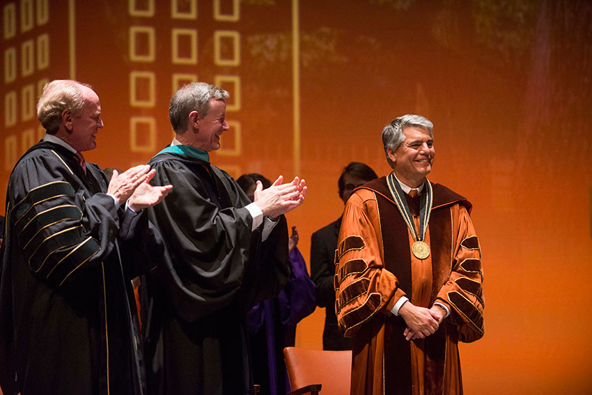 Regent Steven Hicks and Chancellor William McRaven applaud for President Fenves.
