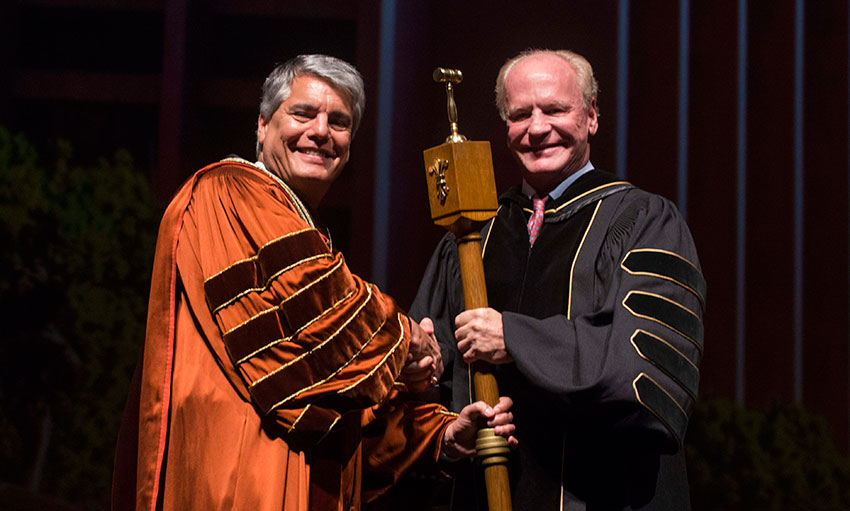 Board of Regents vice chair Steven Hicks gives President Fenves the mace of authority.