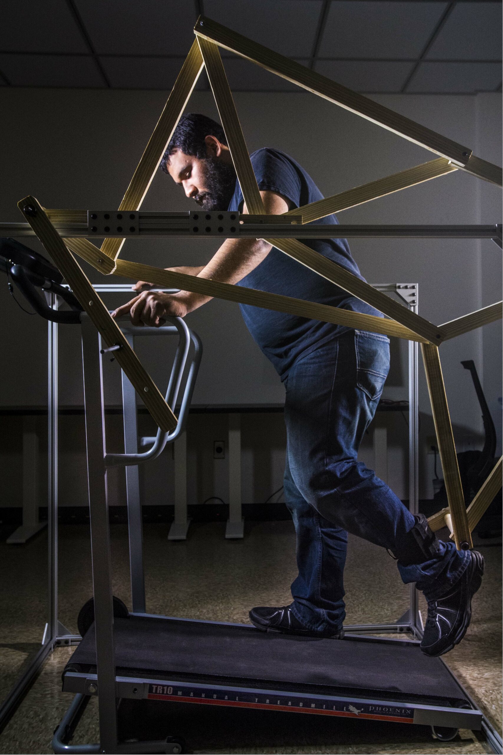 Mendez demonstrating the larger model of the robotic gait trainer.