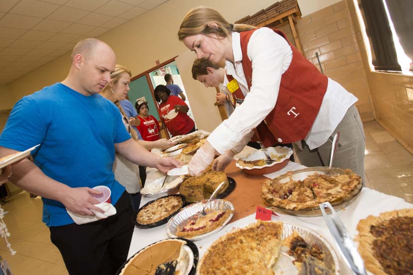 Orange Jackets serve pie to students, family, and staff at the Rosedale School