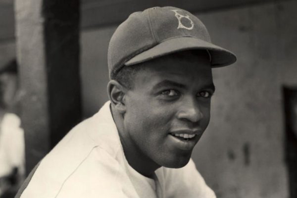 Jackie Robinson smiling from a dugout