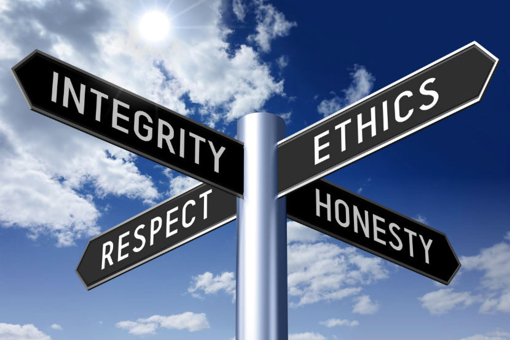  Four signs with the words 'Integrity', 'Ethics', 'Respect', and 'Honesty' on a metal post in front of a blue sky with clouds.