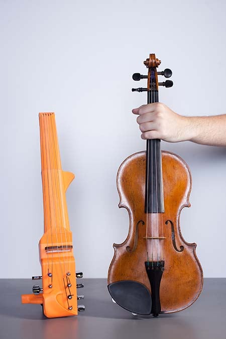 3D printed violin prototype next to a traditional violin.