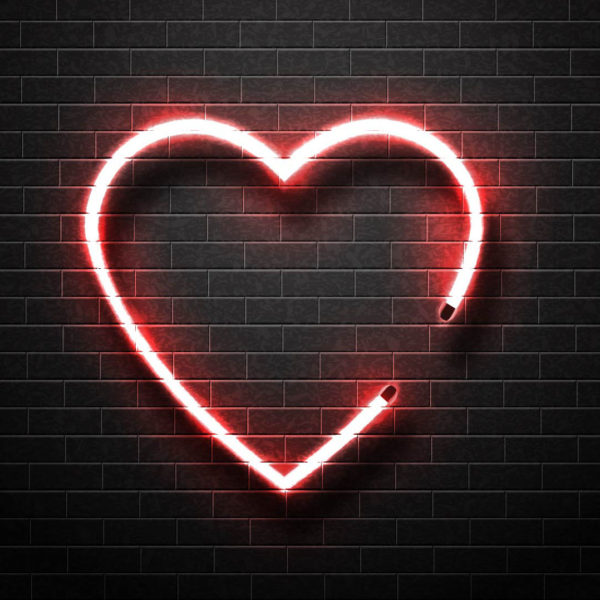 Faux neon Heart illuminated on brick wall