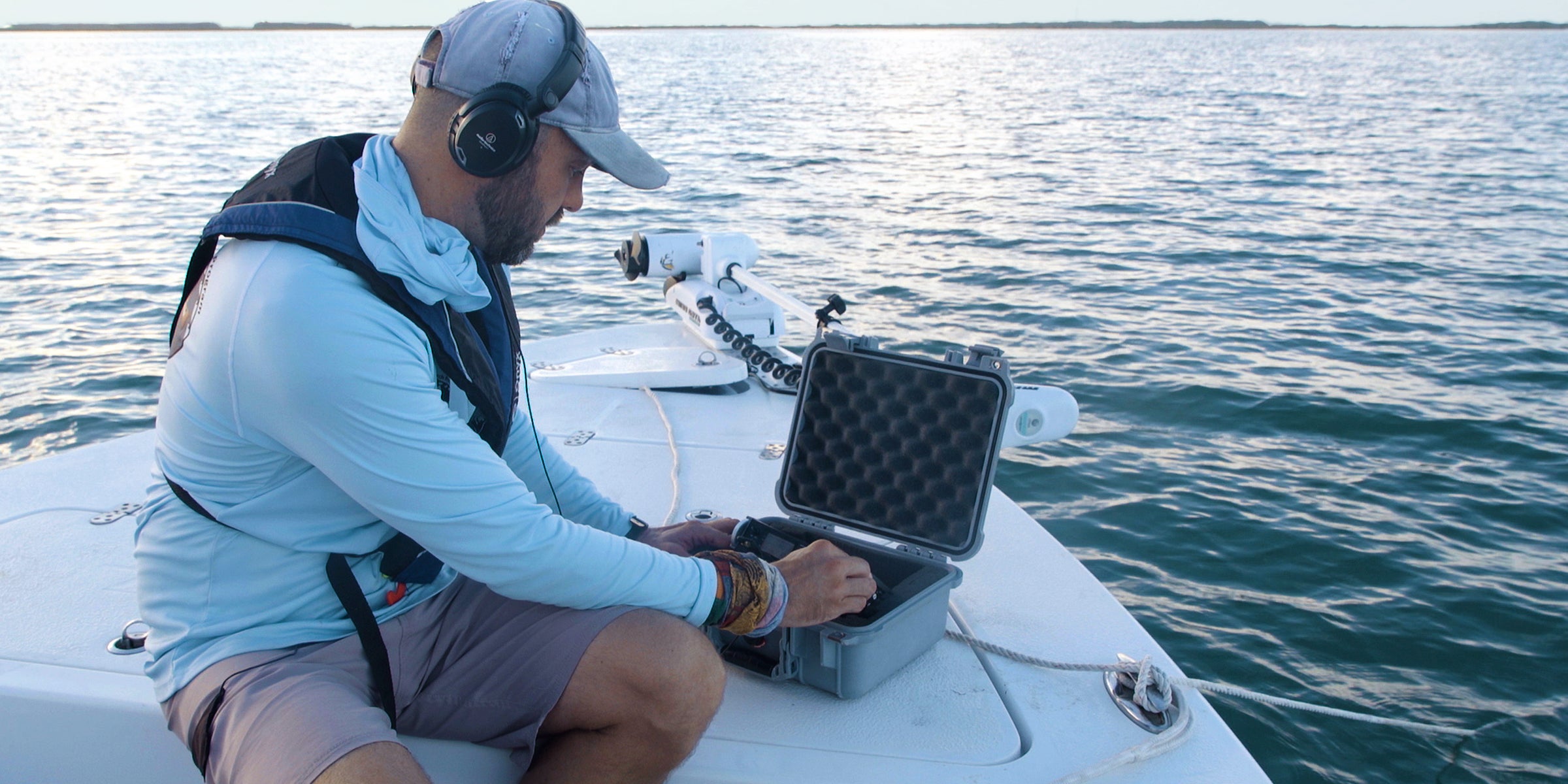 Marine Science Ph.D. candidate Chris Biggs sitting in a small boat listening for seatrout. Marine Science Ph.D. candidate Chris Biggs sitting in a small boat listening for seatrout.