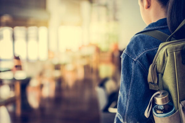 Girl with backpack entering to the classroom.