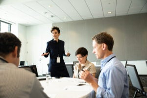 Tamie Glass (standing) answers questions and offers feedback.