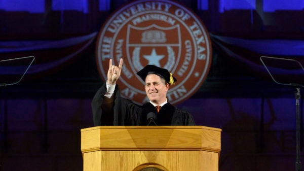 Michael Dell doing hook'em horns sign.