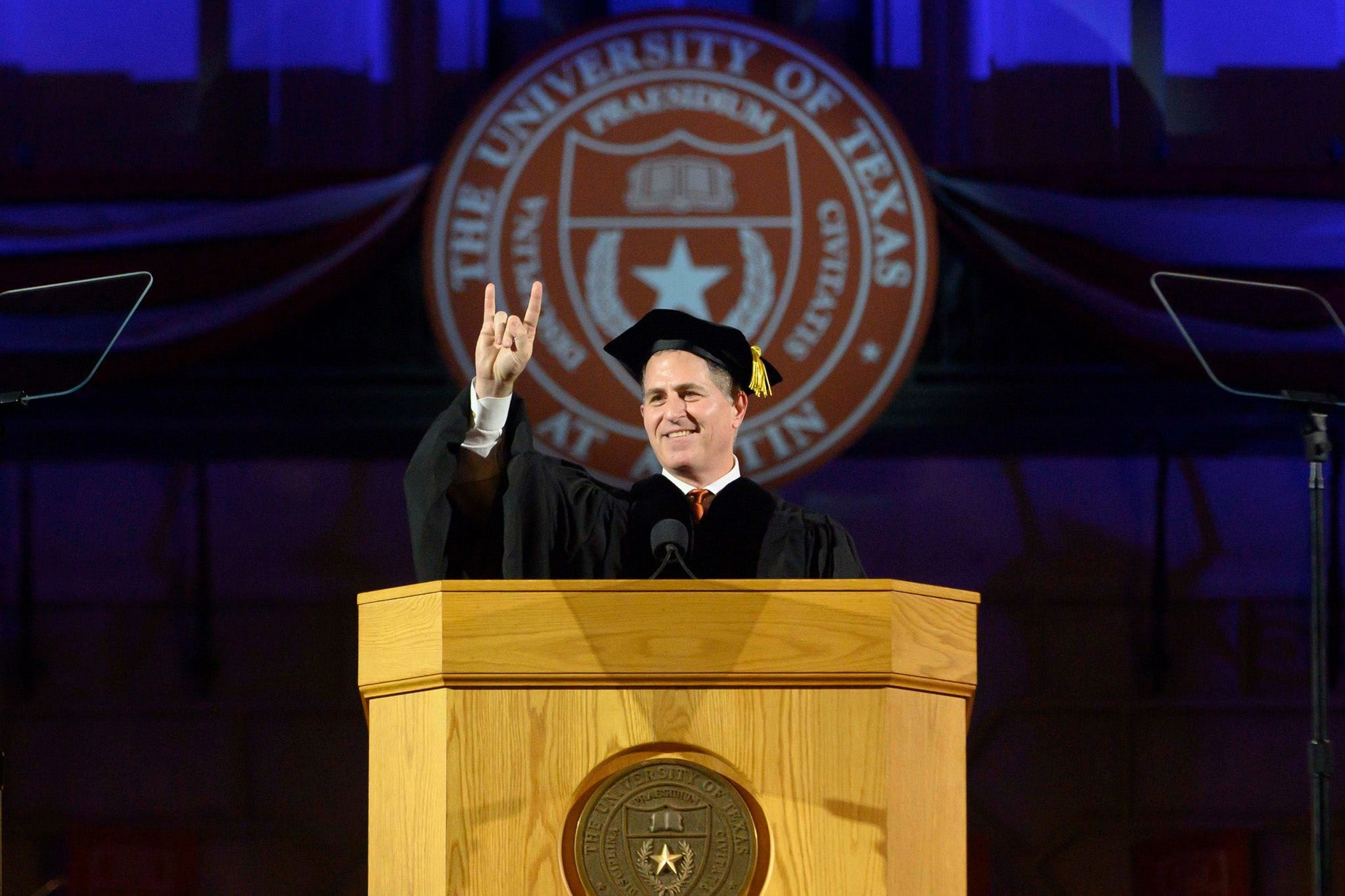 Michael Dell doing hook'em horns sign.