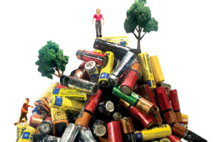 A pile of used batteries with small figures of people and trees.