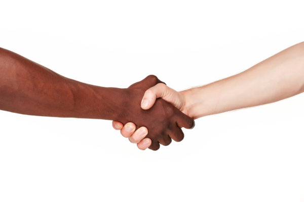 Black and white human hands in a modern handshake