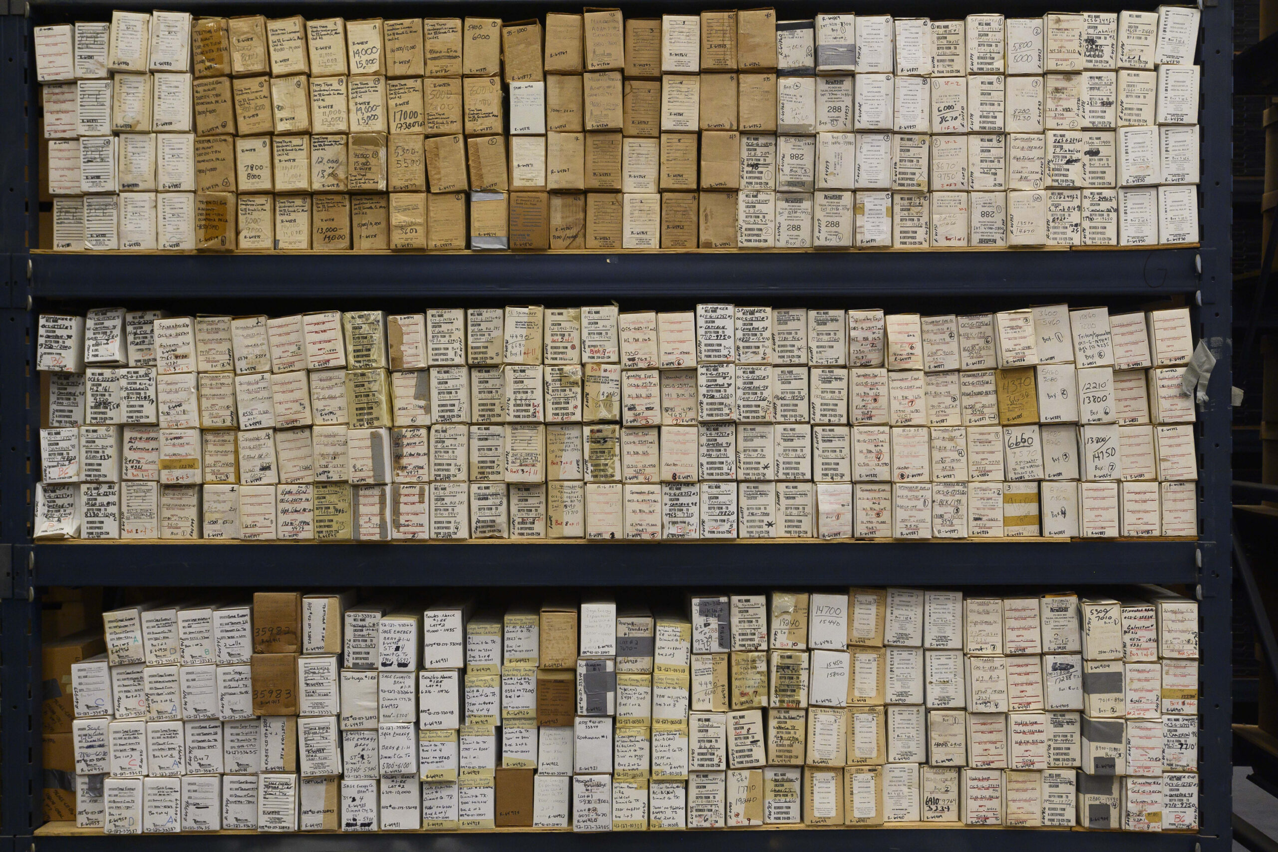 Rows of small brown boxes that contain core samples, all labeled with the location of the well, the date, etc.