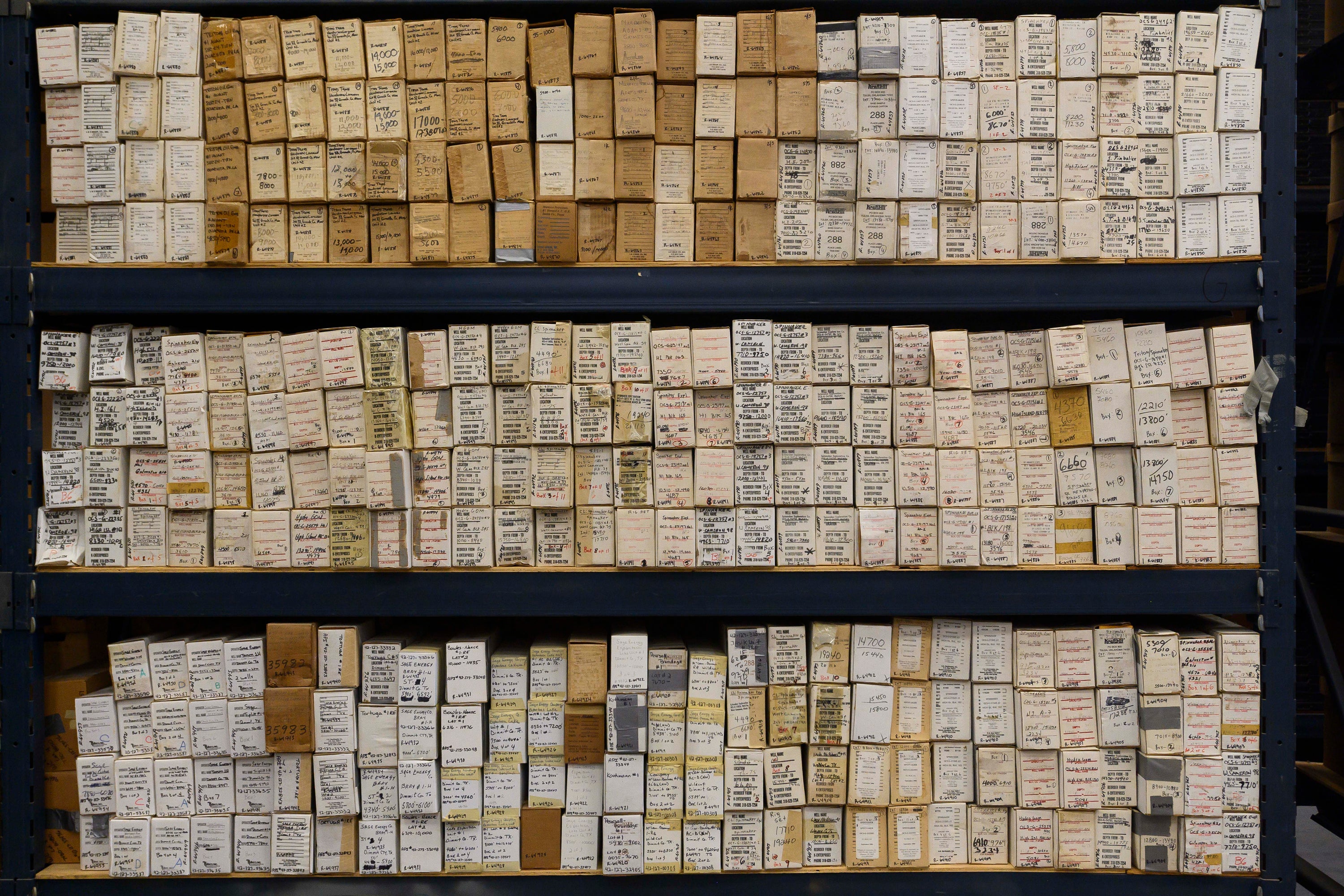 Rows of small brown boxes that contain core samples, all labeled with the location of the well, the date, etc. Rows of small brown boxes that contain core samples, all labeled with the location of the well, the date, etc.