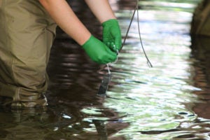 Texas high school student fishing for trash samples.