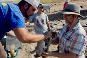 Associate Professor Rabinowitz and colleague examine Roman artifact.