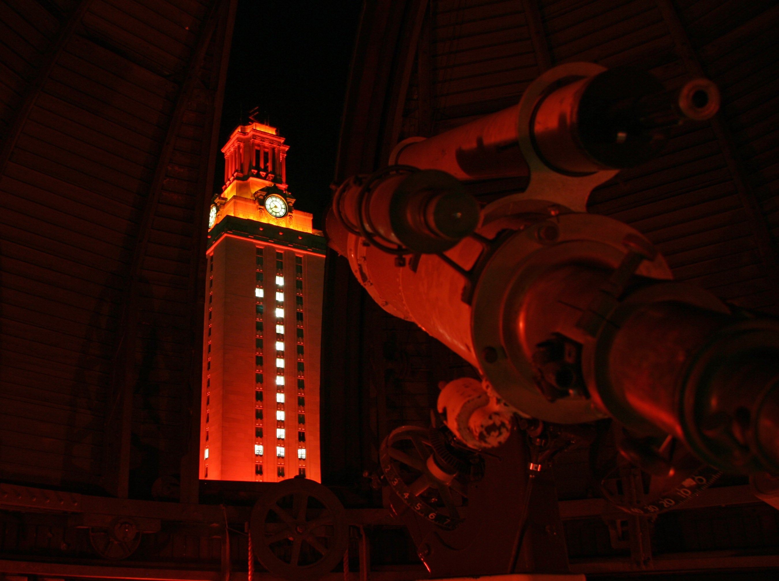 A photo of the Painter telescope and the UT Tower at night.