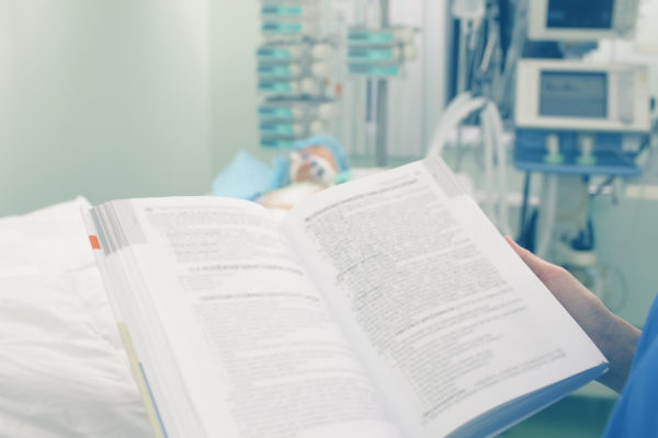 Reading medical book in patient ward