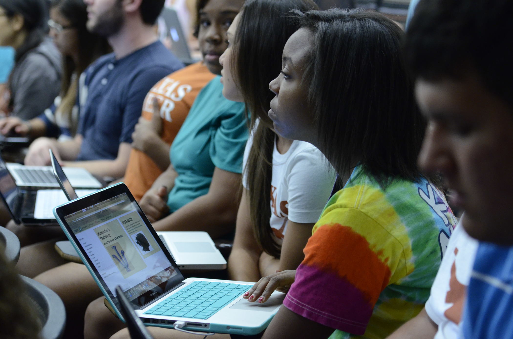 Woman with laptop listens in classroom