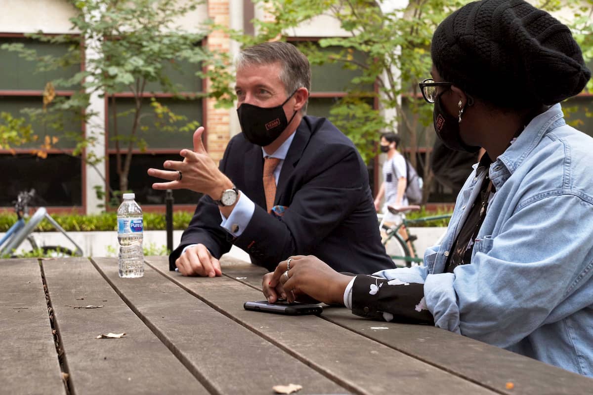 Jay Hartzell, sitting, table, outdoors, student, talking