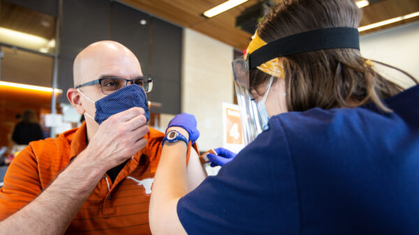 Social Work professor Ruben Parra-Cardona receives the Covid-19 vaccine in the Health Discovery Building at The University of Texas at Austin. Photo by Montinique Monroe
