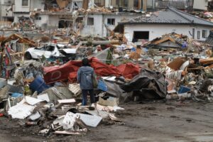 Picture of a child standing among debris and ruined buildings