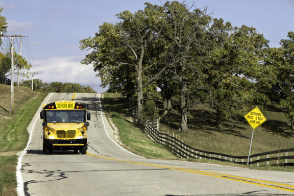 American country asphalt road with school bus sign