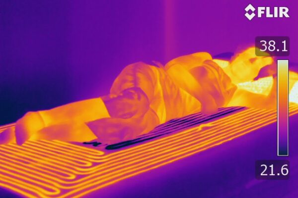 A thermal view shows a person sleeping with the mattress ad different temperatures shown in red and yellow.