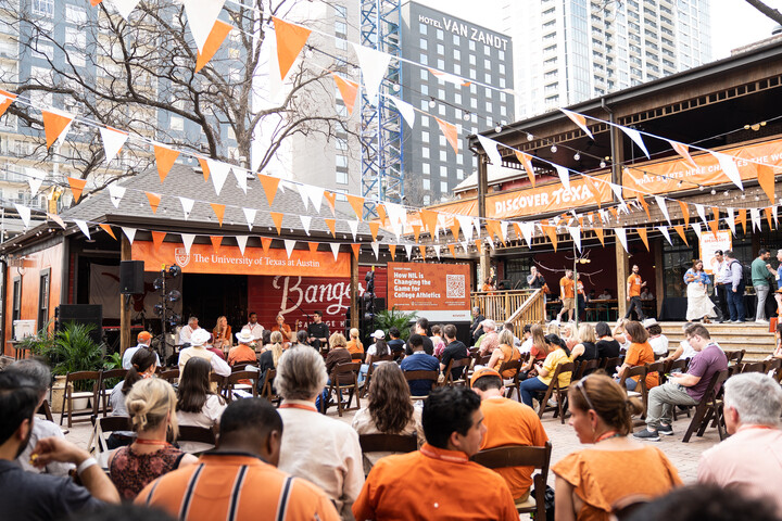 audience of people outside facing stage with burnt orange decorations