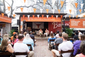 President Jay Hartzell and Jim Breyer on stage in front of audience of people with burnt orange decorations