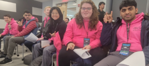students in pink shirts smiling and looking at the camera