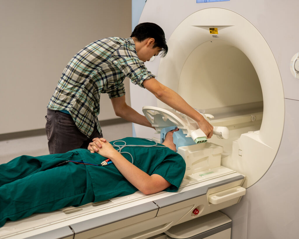 A scientist prepares a patient to go into the MRI machine