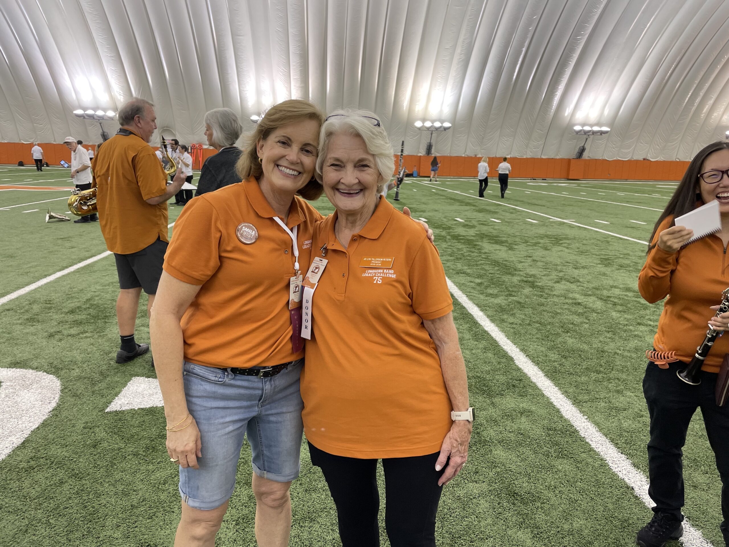 Two women in the Alumni Band pose inside the practice Bubble