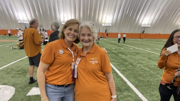 Two women in the Alumni Band pose inside the practice Bubble