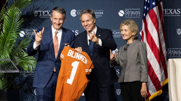 President Jay Hartzell and former U.S. Senator and UT cheerleader Kay Bailey Hutchison present Secretary of State Antony Blinken with a Longhorn jersey.