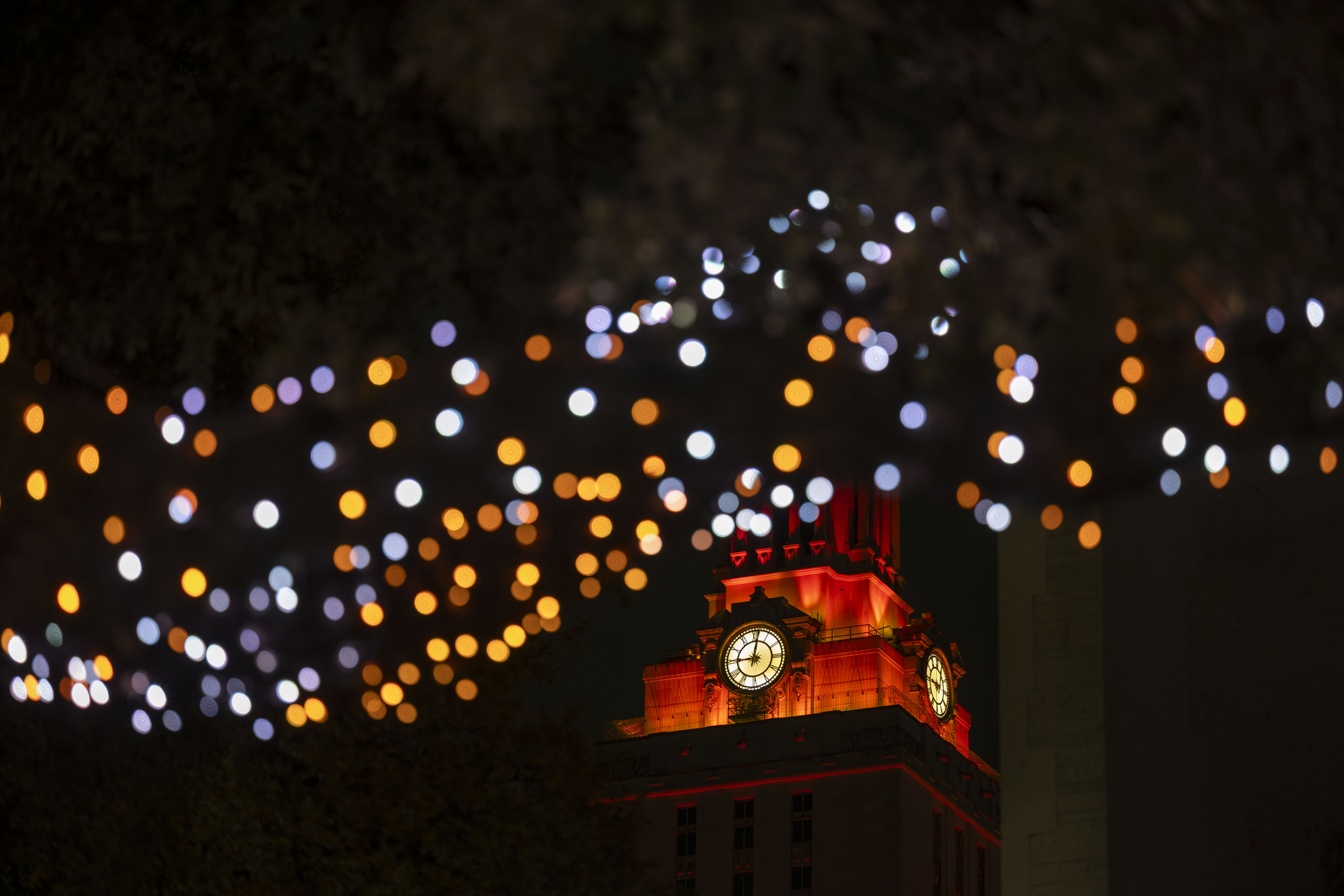 close up of holiday lights with orange ut tower in background