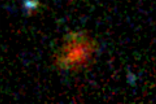 A diffuse red patch in the center of an inky black background
