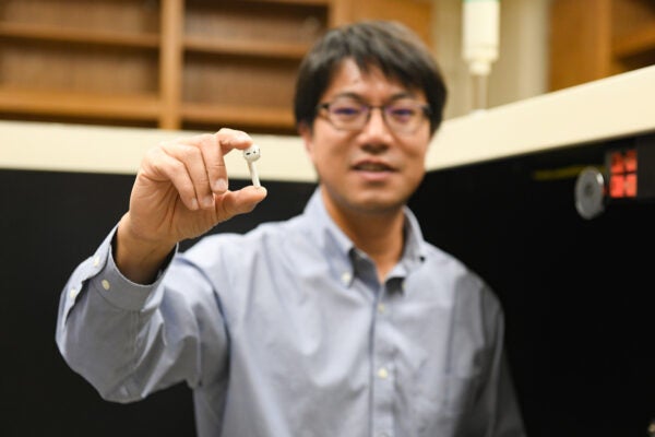 Yijin Liu holding an earbud