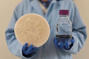 A scientist holding a biomass and a bottle of water