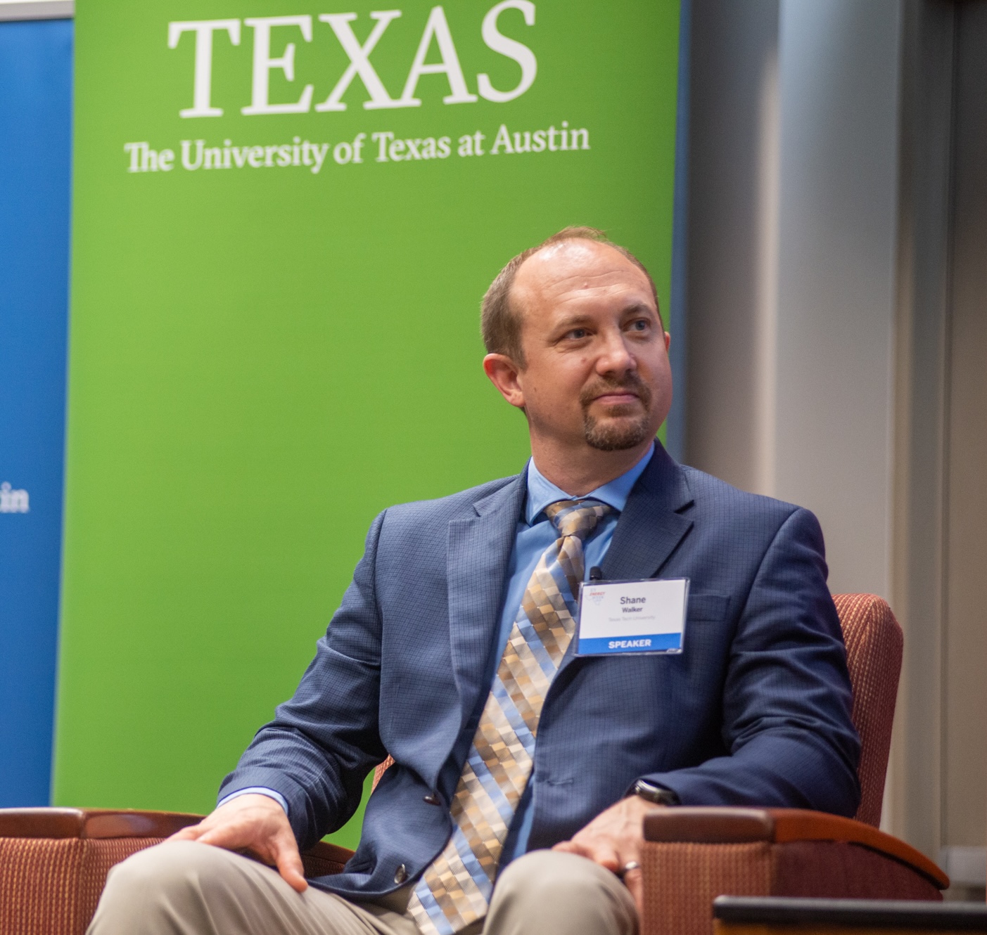 man in chair on stage during discussion